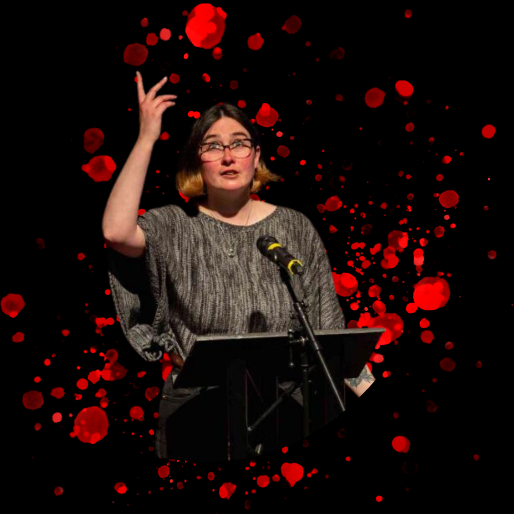 Megan Pattie (a white woman with glasses, a grey sweater and dark brown hair with light tips) is pictured standing in front of a lectern and microphone. The background is black with red splotches, evocative of stylised bloodstains.